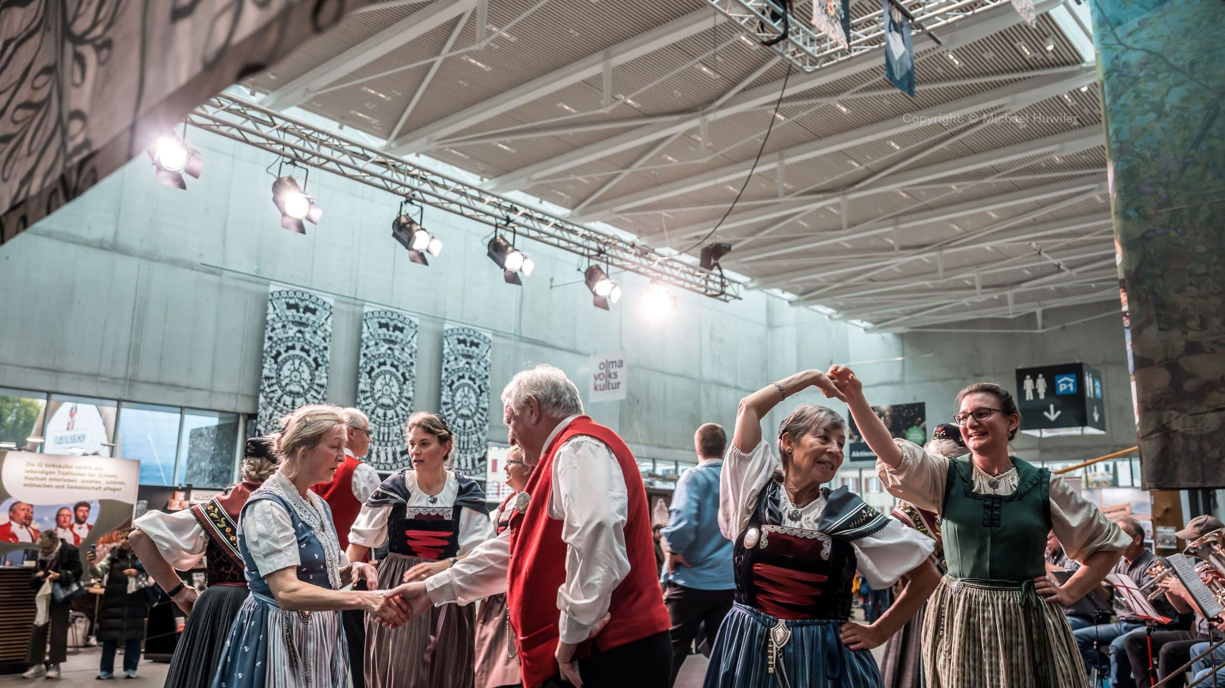 Menschen in Trachten tanzen in einer Messehalle der OLMA St.Gallen